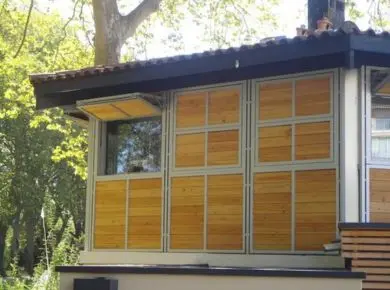 Cabanon touristique ou tourelle ayant posé des systèmes de brise soleil horizontaux relevables, avec zone d'ombre au dessus de la fenêtre grâce à la formation de l'auvent.