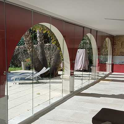 fermeture en verre sur mesure d'une terrasse couverte en dur avec des arches