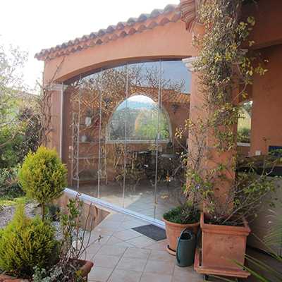 vue extérieure d'un Rideau de Verre posé pour fermer une terrasse couverte en arches