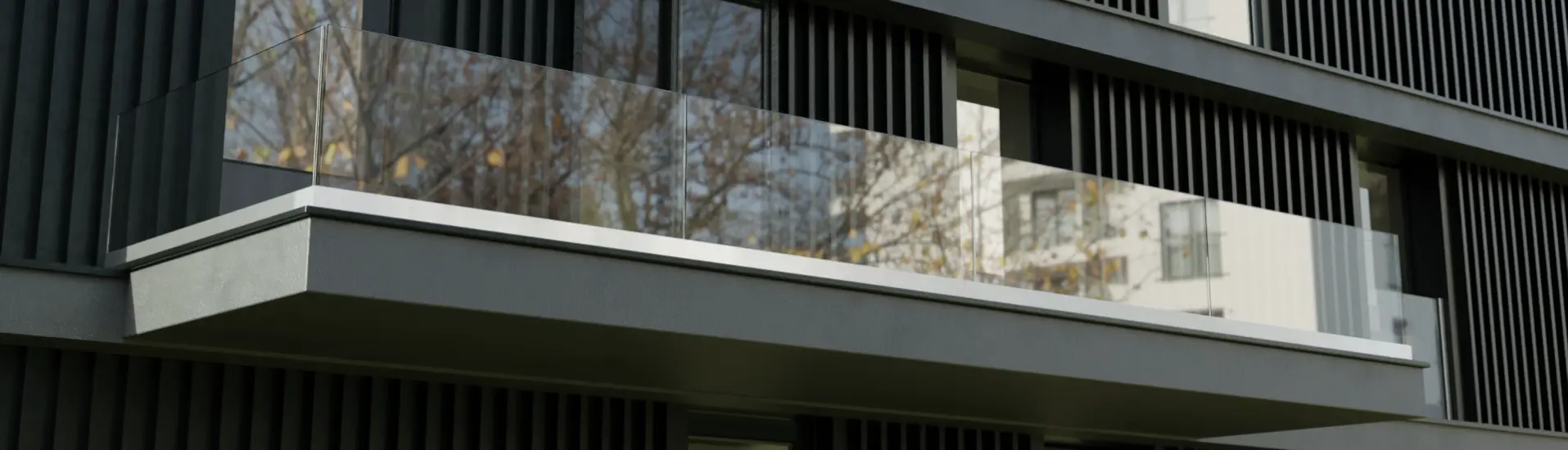 Immeuble en copropriété pourvu des balustrades en verre aux fenêtres coulissantes et un garde-corps en verre sur le toit terrasse
