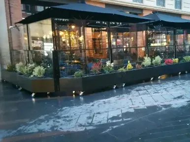 Aménagement d'une terrasse extérieur délimitée par la formation d'un ensemble de paravents extérieurs télescopiques sur roulettes et jardinières