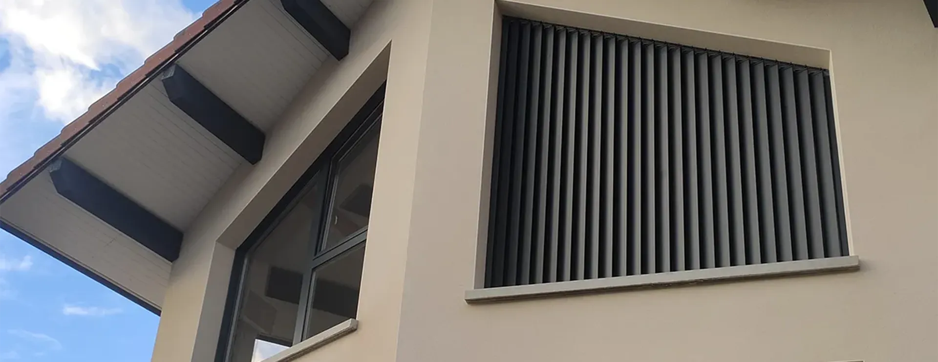 Résidence immoblière aménagée avec des brise-soleil de type volet coulissant et claustra brise vue en bois