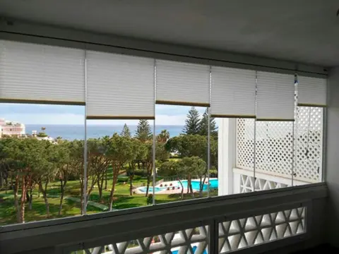 Vue intérieure d'un balcon avec Rideau de Verre fermé et positionnement haut des stores plissés