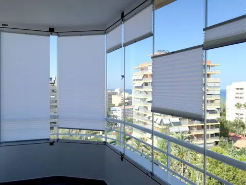 Balcon en angle fermé par un Rideau de Verre avec des stores plissés.