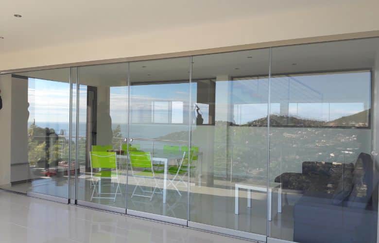 Système de fermeture en verre panoramique avec le Coulissant Panoramique Glass Systems pour aménager un salon de jardin en terrasse