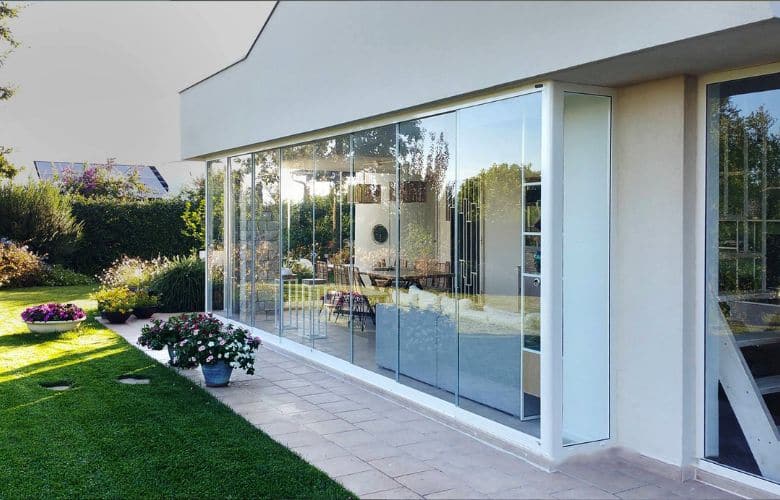 aménagement d'une terrasse couverte pour fermer un jardin d'été avec un verre panoramique de type Rideau de Verre ou Coulissant Panoramique