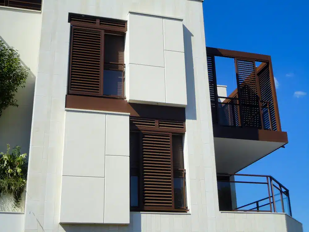 Brise-soleil installés en façade d'immeuble en guise de volets coulissants et une partie sur une terrasse pour se protéger du vent et du vis-à-vis