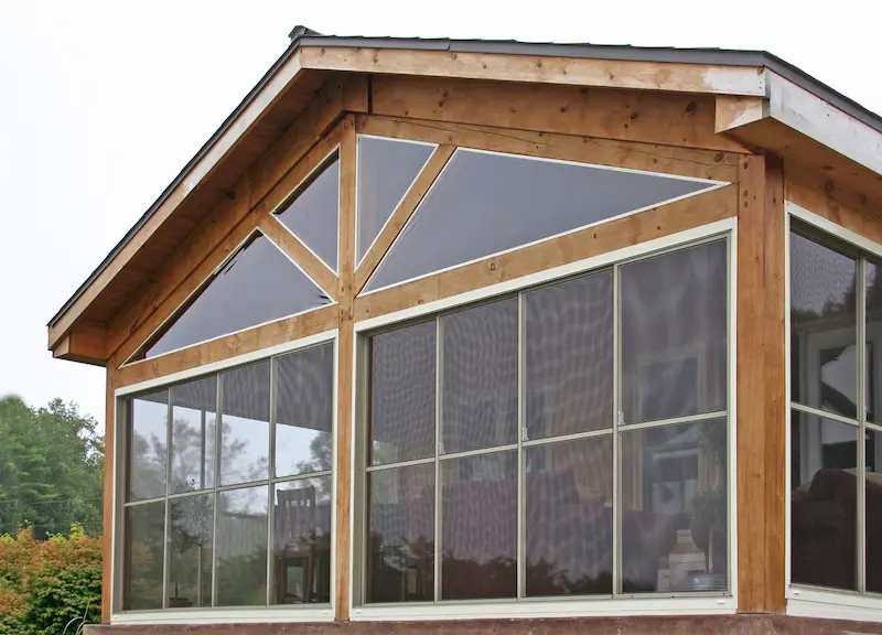 Moustiquaire coulissante sur mesure avec panneaux amovibles installée sur une baie vitrée d'une maison située en pleine campagne