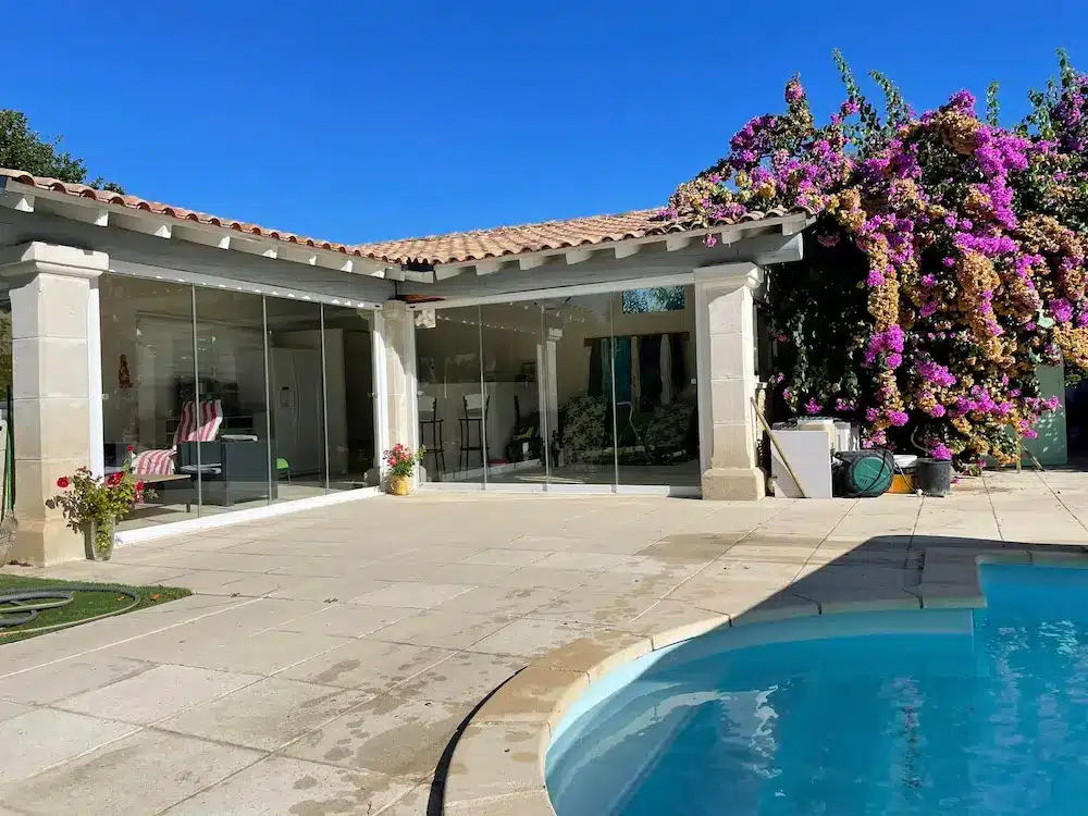 Terrasse couverte transformée en pool house avec fermeture coulissante pivotante