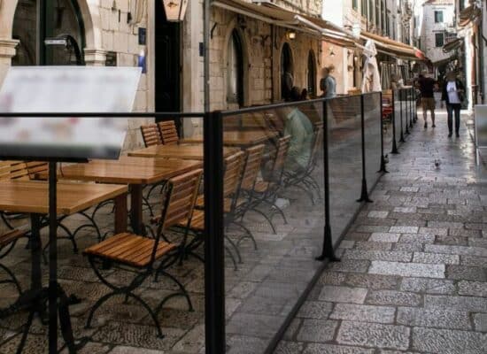 Paravent extérieur de terrasse de restaurant dans une rue pavée.