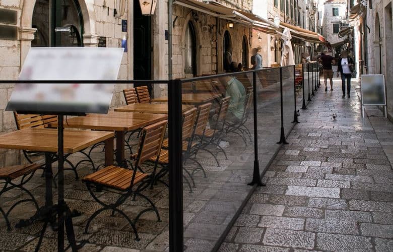 Paravent extérieur de terrasse de restaurant dans une rue pavée.