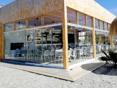 Alternative au Rideau de Verre, le Coulissant Panoramique est un système de fermeture en verre coulissant pour fermer terrasse pergola et balcon