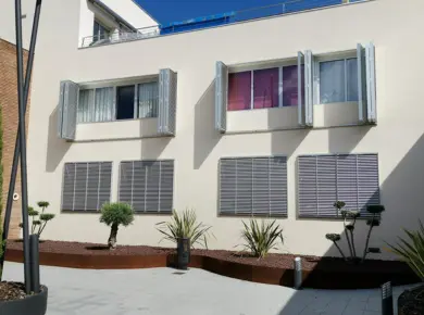 Brise-soleil Accordéon installé en guise de volets pliants en applique à plusieurs vantaux pour fermer fenêtres en enfilade.