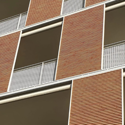Brise-soleil orientable pour balcon installé en façade comme volet coulissant ou roulant en aluminium et lames en bois thermodur.