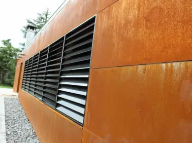 Installation de brise-soleil à lames fixes en guise de panneau claustra pour cacher des éléments techniques et permettre à l'air de circuler dans la zone.