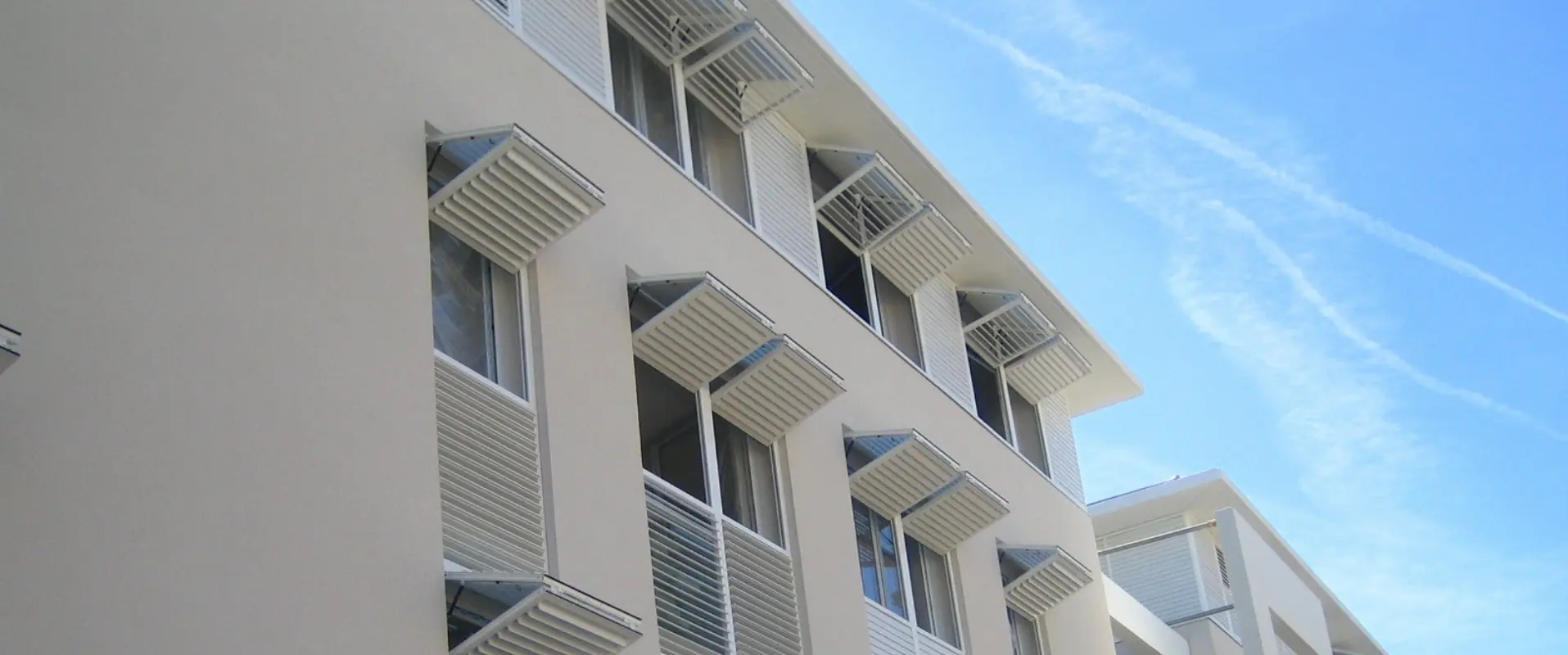 Brise-soleil horizontal avec une série de volets papillon installée sur mesure et en aluminium