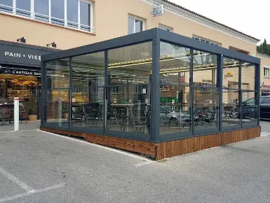 Pergola aluminium fermée par un ensemble de paravents extérieurs télescopiques