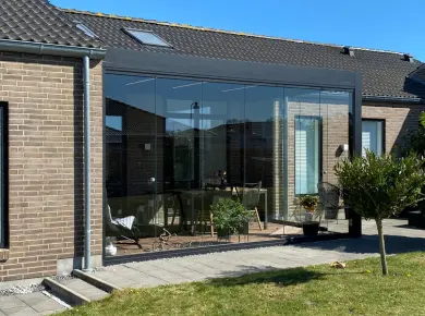 Pergola bioclimatique sur mesure avec un poteau et l'installation d'un Rideau de Verre pour fermer la pergola et la terrasse