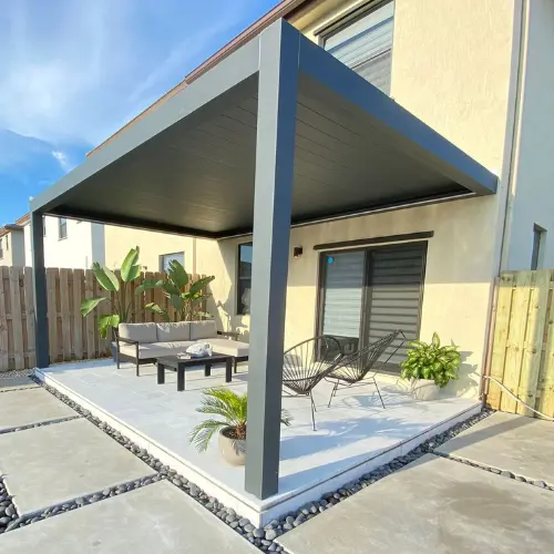 Pergola bioclimatique adossée en aluminium comme toit de terrasse