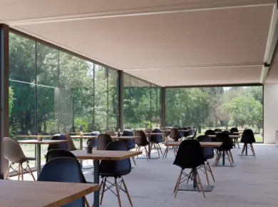 Vue intérieure sous une pergola à toit plat type carport utilisée comme espace de restauration ou de coworking