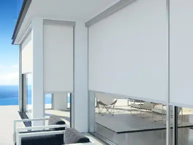 Installation de store blanc vertical extérieur micro perforée et motorisé en bord de mer, avec une exposition au vent, marée et soleil